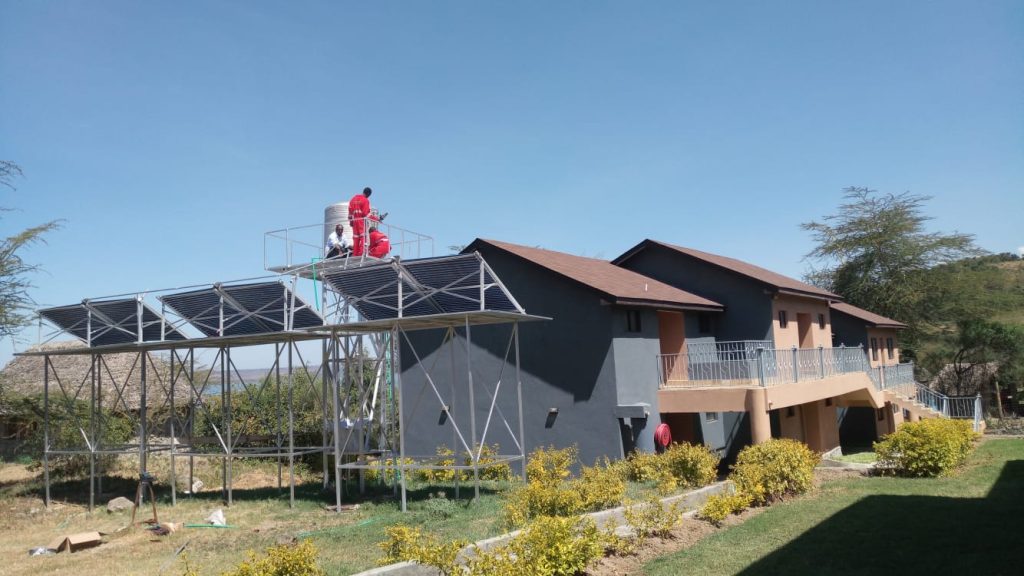 Evacuated tube collectors on a raised steel frame beside the grey lodge buildings at Pelican Lodge, Naivasha
